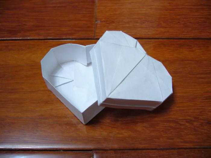 Открытая коробочка в технике оригами в виде сердца станет отличным дополнением к сувениру сделанным в течение нескольких минут при помощи схем и детального описания предоставленного в статье